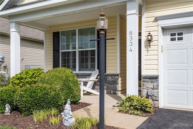 Property entrance with covered porch and stone siding