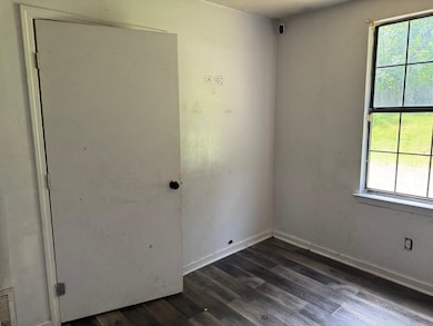 Empty room with dark wood finished floors and base