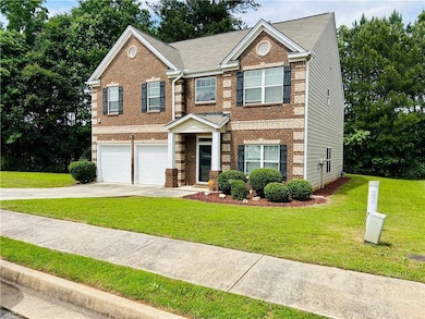 View of front of house featuring driveway, brick siding, an attached garage, and a front yard
