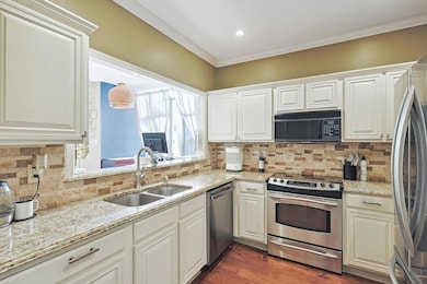 Kitchen with dark wood-type flooring, sink, orname