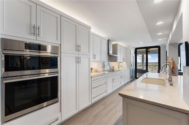 Kitchen featuring light stone countertops, light w