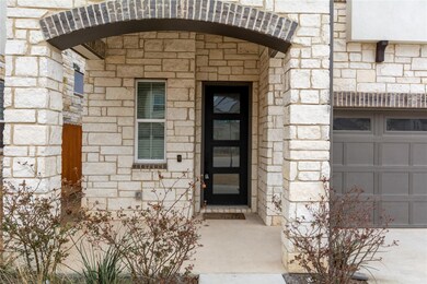 Property entrance with stone siding and a garage