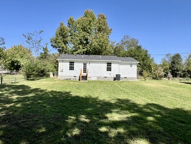 This is a picture of the back of the house and the large backyard.   Someone could add a nice deck to go along with the stairs.