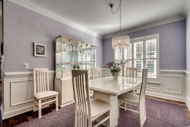 Dining area with crown molding, dark hardwood / wood-style floors, and an inviting chandelier