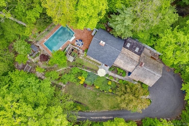 This aerial view captures the full scope of the property - from the main residence to the pool, brick patio, and vegetable garden.