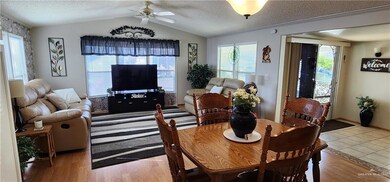 Dining room with vaulted ceiling, light tile floors, a textured ceiling, and ceiling fan