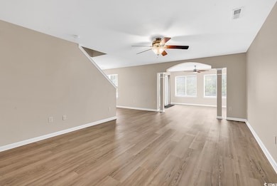 Unfurnished living room featuring ceiling fan, bas