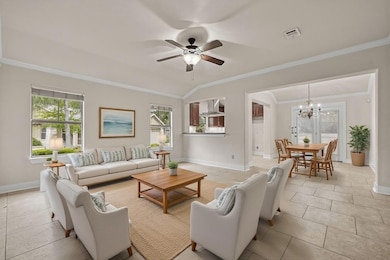 Virtually staged living room full of natural light with dining and kitchen in the background.