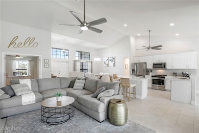 Living room with a ceiling fan, high vaulted ceili