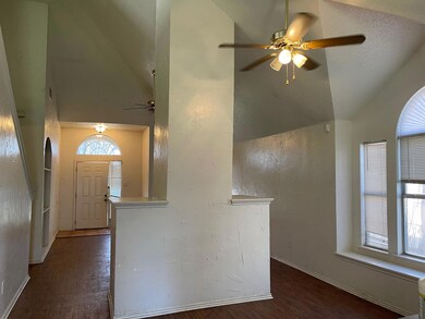 Entryway featuring high vaulted ceiling and dark w