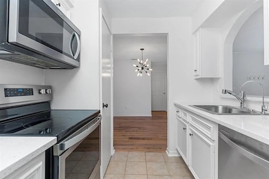 The heart of the home! This remodeled kitchen features white painted cabinets, stainless steel appliances, a pantry, and quartz countertops.