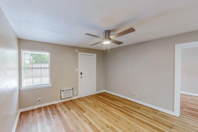 Unfurnished room featuring ceiling fan, wood-type flooring, and an AC wall unit