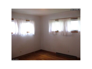 Bedroom 1 has hardwood floors and two windows that