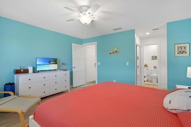 Bedroom with wood finished floors, ceiling fan, and a textured ceiling