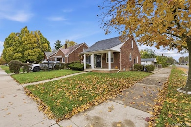 Bungalow with covered porch, brick siding, and a front yard