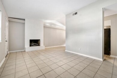Unfurnished living room featuring light tile patterned floors and a brick fireplace