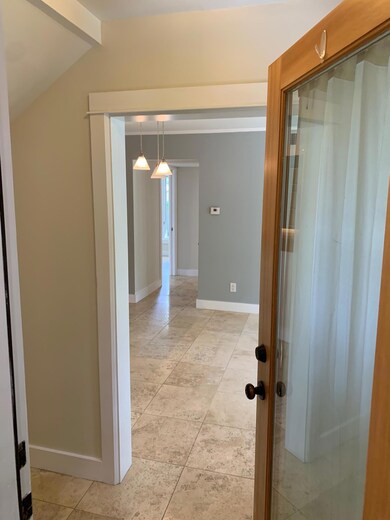 Corridor featuring baseboards, light tile pattern