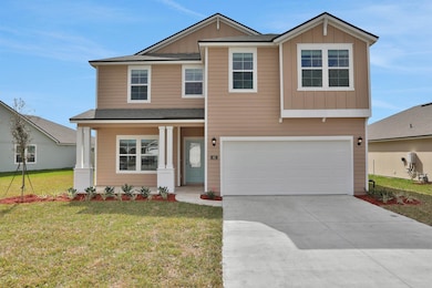 Craftsman-style house featuring board and batten siding, covered porch, a front yard, concrete driveway, and a garage