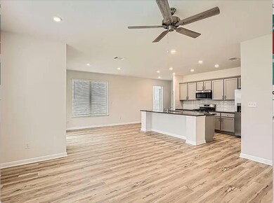 Kitchen with gray cabinets, appliances with stain