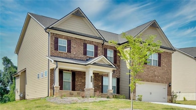 Craftsman house with an attached garage, brick siding, a front lawn, and concrete driveway