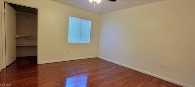 Unfurnished bedroom featuring dark wood finished floors and a spacious closet