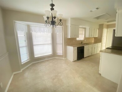 Kitchen with black dishwasher, a notable chandelie