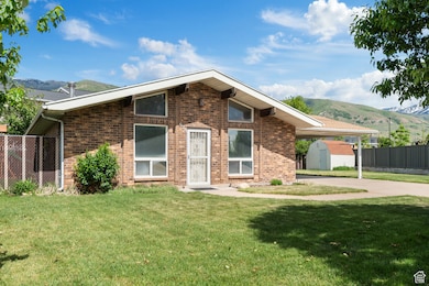 Mid-century home featuring a storage shed, a mountain view, brick siding, and an outbuilding