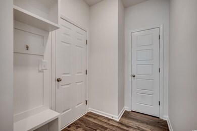 Mudroom featuring dark wood-style floors and baseboards