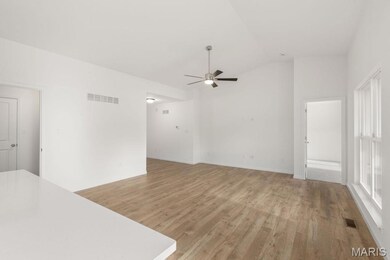 Unfurnished living room featuring lofted ceiling, ceiling fan, and light wood-style floors