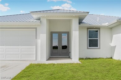 Entrance to property with a garage and a lawn
