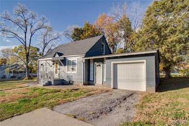 View of front of home with a front yard, roof with shingles, driveway, and a garage