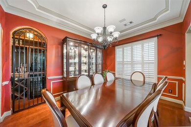 Fabulous tray ceiling, a secluded bar, and a stunning chandelier in this formal dining room.