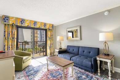 Living area featuring crown molding, a textured ce