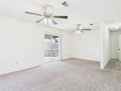 Carpeted spare room with attic access and a ceiling fan