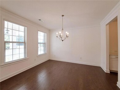 Dining Room with dark wood finished floors, a chandelier, and ornamental molding