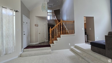 Stairway featuring high vaulted ceiling, carpet flooring, and a chandelier