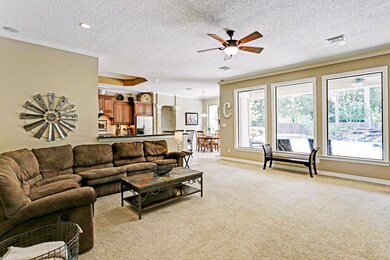 View of the family room when entering. Note the wall of windows overlooking the covered patio, pool and back yard.