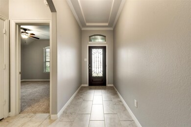 Doorway with ceiling fan, crown molding, and light carpet