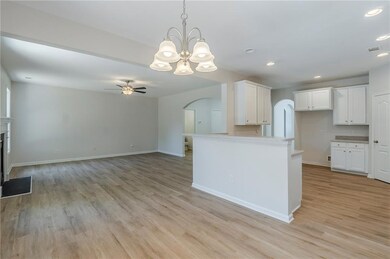 Kitchen featuring arched walkways, recessed lighting, a ceiling fan, light countertops, and light wood-style flooring
