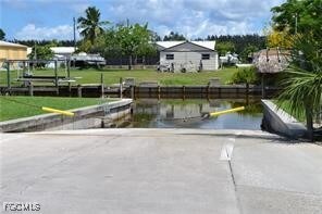 Surrounding community with a boat ramp, a water view, and a boat dock
