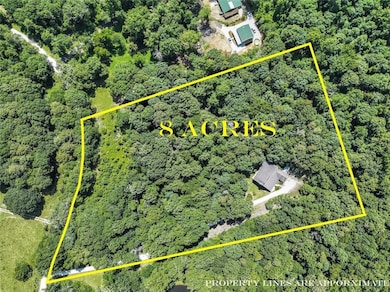 Aerial view of property's location featuring property parcel outlined and a heavily wooded area