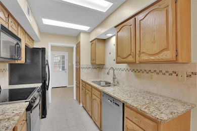 Kitchen featuring tasteful backsplash, light tile 