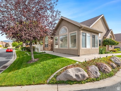 View of side of property with stucco siding, a yard, and roof with shingles