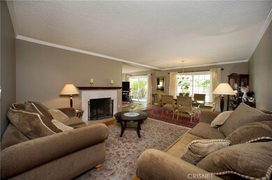 Elegant living room warmed by the fireplace, highlighted by gleaming original wood floors