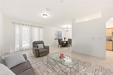 Living room with light tile patterned floors, a chandelier, and arched walkways