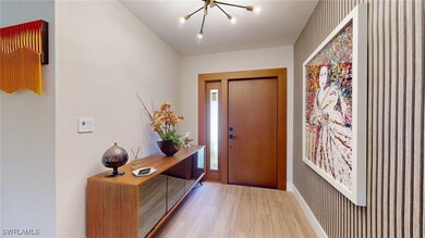 Entryway featuring an inviting chandelier, baseboa