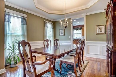 Formal Dining Room with Wood Flooring, Tray Ceilin