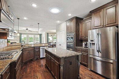 Kitchen featuring ceiling fan, dark wood-type floo