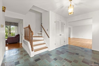 Staircase with stone tile floors and baseboards