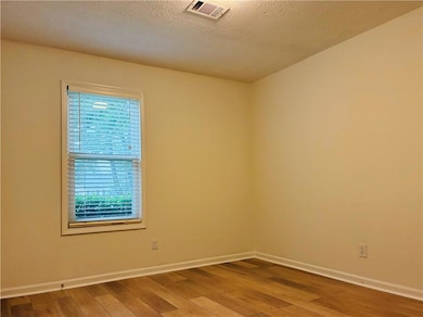 Empty room with wood-type flooring and baseboards